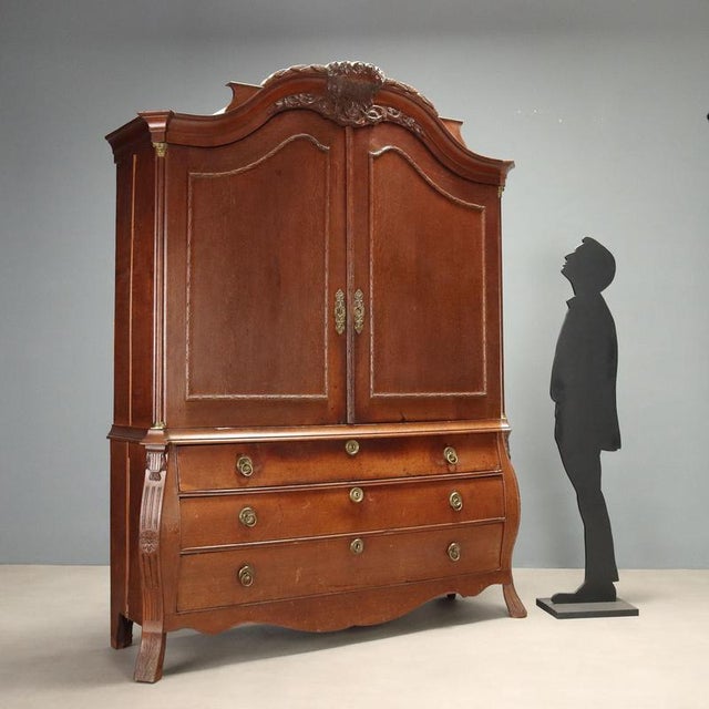 Mid-19th century Dutch oak cabinet featuring an elegant serpentine front base with three drawers. The pilasters, cut at...