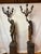 Masterfully crafted with a rich, dark patina on the figures, these candelabras feature elegant, contrasting gilded accents...