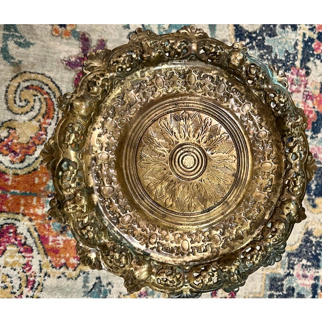 Offering highly decorative antique brass pedestal table featuring an intricately pierced and repoussé-style round top. The...
