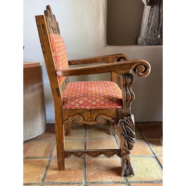 An imposing Spanish Colonial Revival armchair crafted from dense hardwood with a rich, honey-brown patina. Borrowing from...