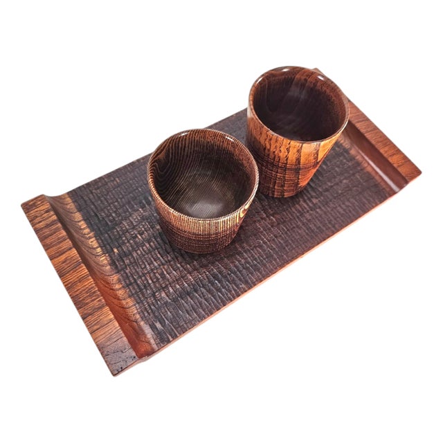 Evoking the quiet artistry of traditional craftsmanship, this hand-turned wood tray and cup set embodies the refined...