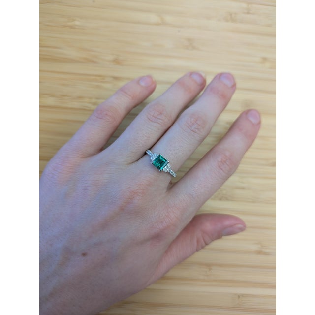 A beautiful Asscher-cut Colombian Emerald takes center stage in this elegant 14K white gold ring. Earth-mined diamond...