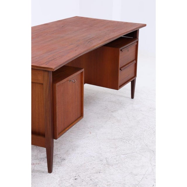 Vintage boomerang-shaped desk made of teak with a beautiful grain and a clean, balanced form. On the right are two...