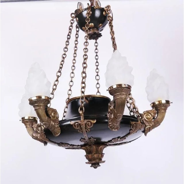 A beautiful Empire-Style six light chandelier with six flame-form shades in frosted glass. Each cornucopia arm is made...