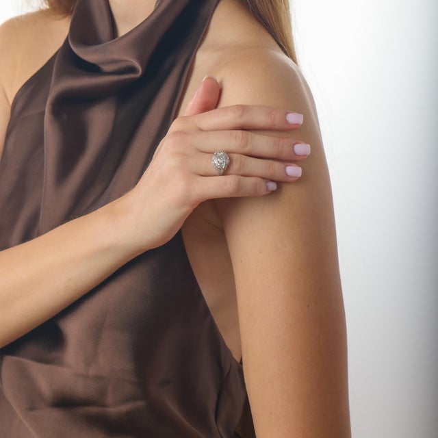 This graceful Edwardian ring is a refined example of early 20th-century elegance, where delicate design and antique...