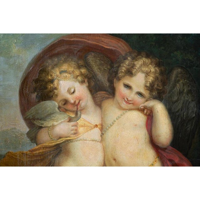 An antique oil painting on wood depicting a pair of winged cherubs in a landscape, dating from the late 18th century. The...