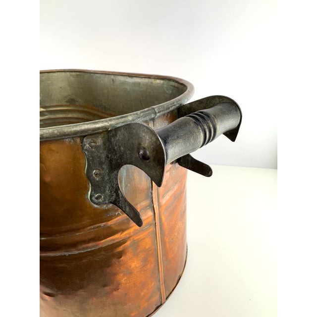 A substantial antique copper wash boiler dating to the late 19th century, retaining its original iron handle mounts and...