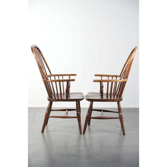 We are offering this lovely antique set of two English Windsor stickback chairs from the 19th century, made of elm wood....