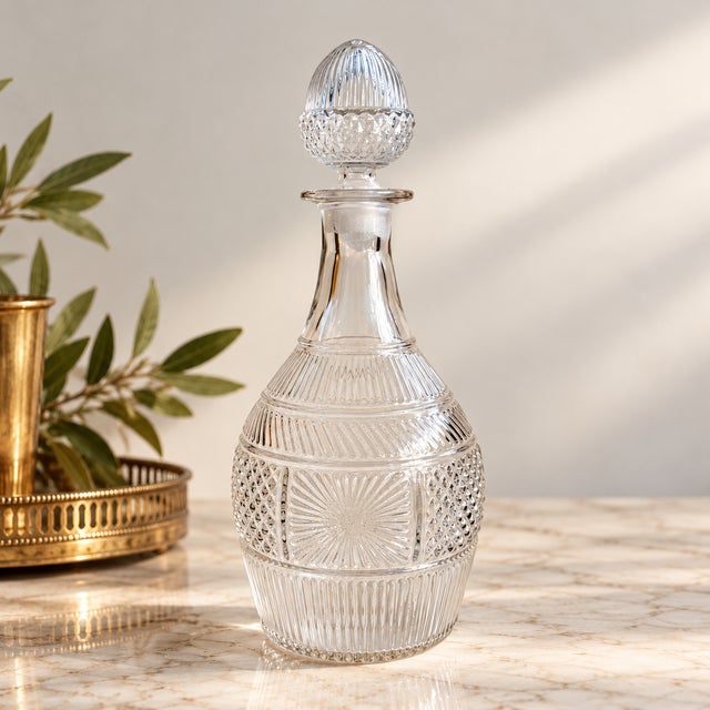 An elegant vintage glass decanter attributed to the Metropolitan Museum of Art's 1970s reproduction collection, inspired...
