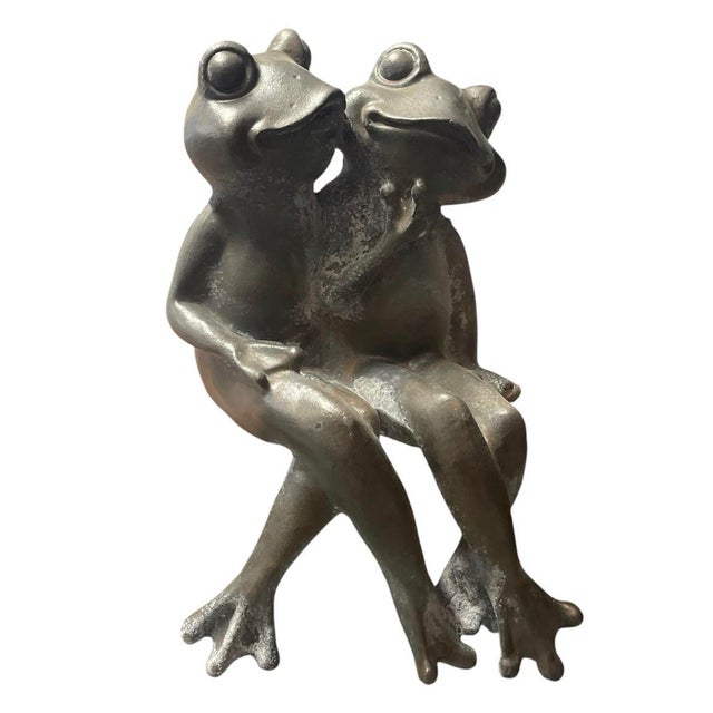 Add a touch of endearing charm to your garden, patio, or interior decor with this vintage cast iron statue featuring a...