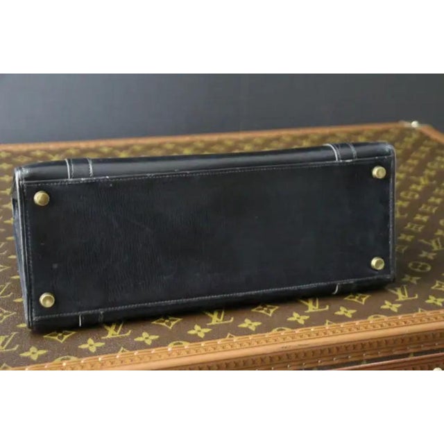 This Hermes Drag bag features black calfskin leather with its two golden plated H-closure buckles .Its double leather...
