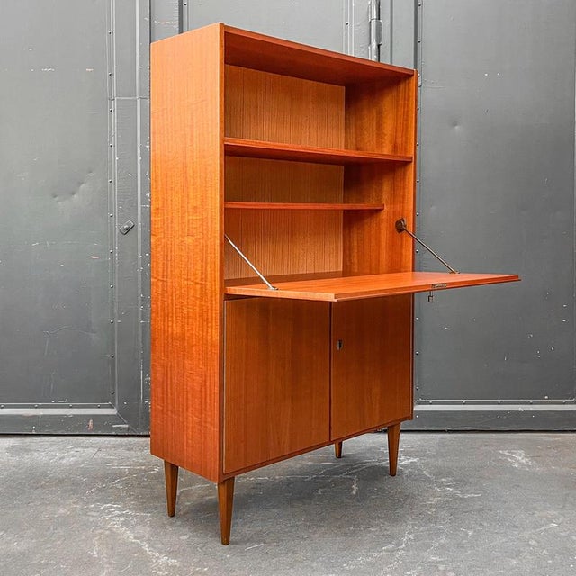 Product: writing desk style: mid-century · 1960s material: mahogany veneer features: practical shelf above · fold-down...