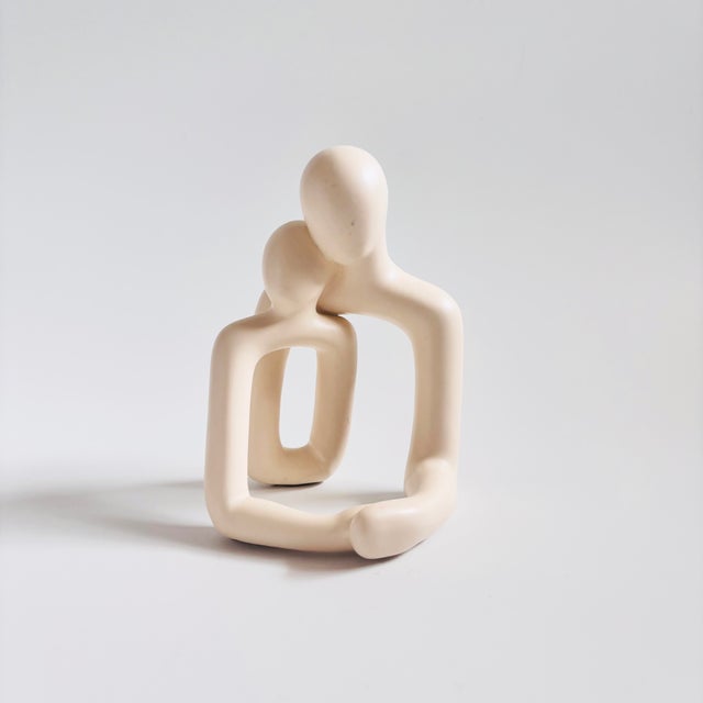 A vintage figurative ceramic sculpture. Beautiful minimalist design of 2 embracing figures. Finished in a matte off-white...