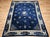 A graceful 19th century Chinese Art Deco rug in a near-square room-size format, featuring a deep navy blue field of...