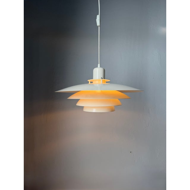 An original Danish pendant lamp from the 1970s, attributed to Form-Light. The lamp features a distinctive multi-layered...