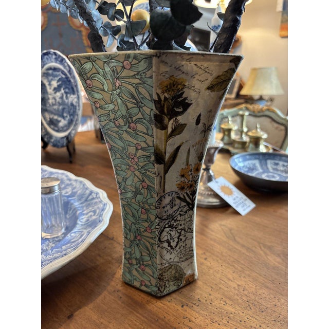 Tall fluted glass vase decorated with a decoupage collage of botanical prints, foliage patterns, and antique map fragments...