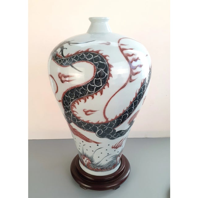 Chinese porcelain dragon meiping, a plum shaped vase with a white glazed exterior, interior, and a partially glazed, inset...