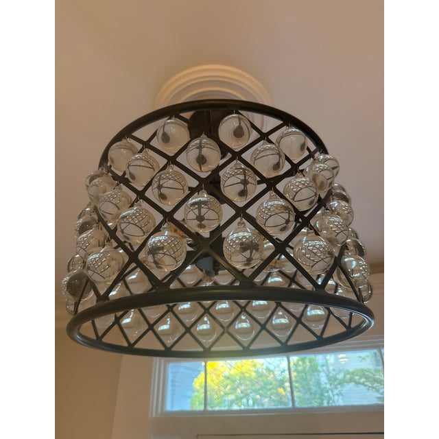 This fixture features an oil-rubbed bronze/matte black iron drum frame arranged in a classic open diamond-grid silhouette....
