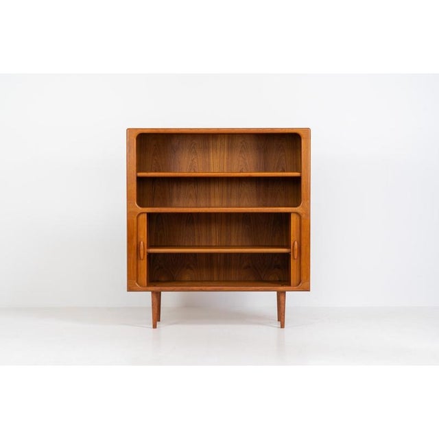 Beautiful bookcase in teak by Svend Dyrlund with tambour doors (Denmark, 1960s). This bookcase perfectly combines organic...
