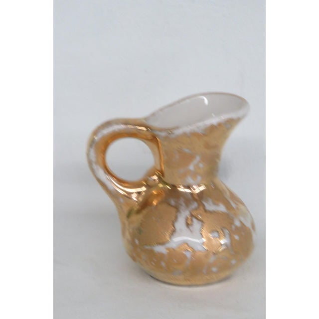 This lovely Pocono Crest Miniature Pitcher is made of ceramic. This dainty collectible features a gorgeous "Weeping Gold"...