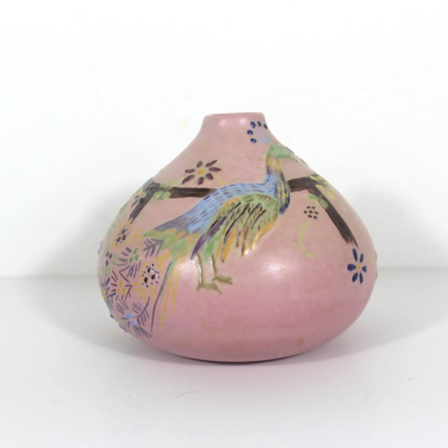 Squat pink ceramic vase with a peacock and flowers. There are raised details on this. It is really lovely and colourful....