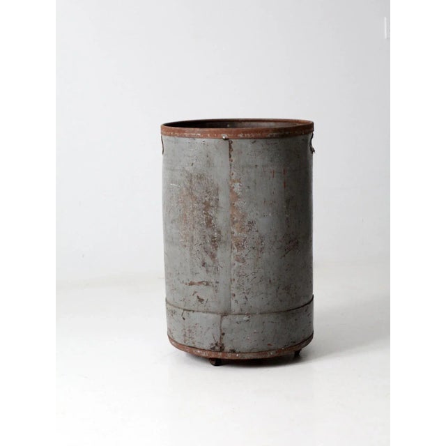 This is a vintage industrial storage can on casters. The gray vulcanized card barrel features a metal base and framing. It...