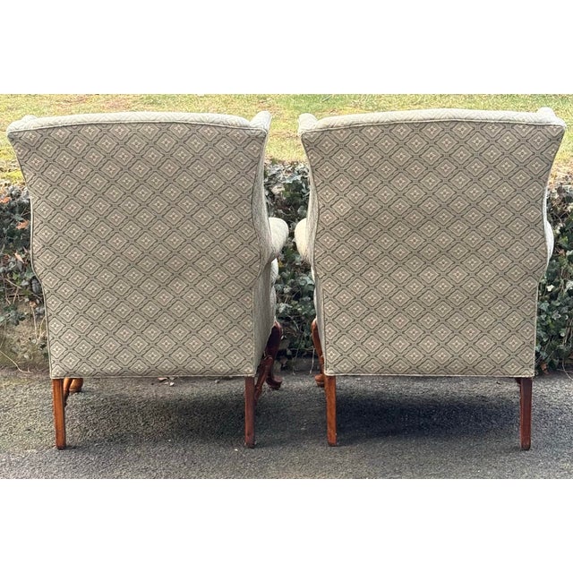 Stately pair of wingback chairs featuring elegant cabriole legs with shell carved detailing on the knees,H-shaped...