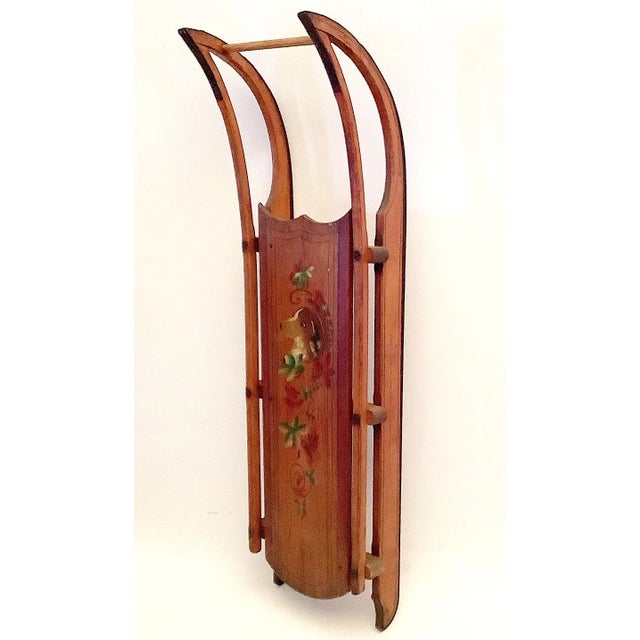 Late 1800s wood sled with hand painted dog, leaves and stenciling. Red border around sled with stenciling on runners are...