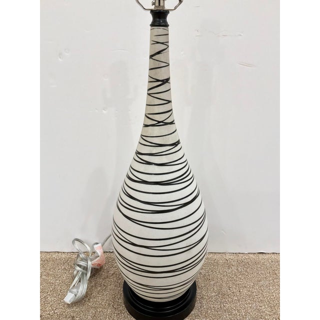 Modern Currey & Co Long Neck Porcelain Lamp with black swirl design. Black round base.