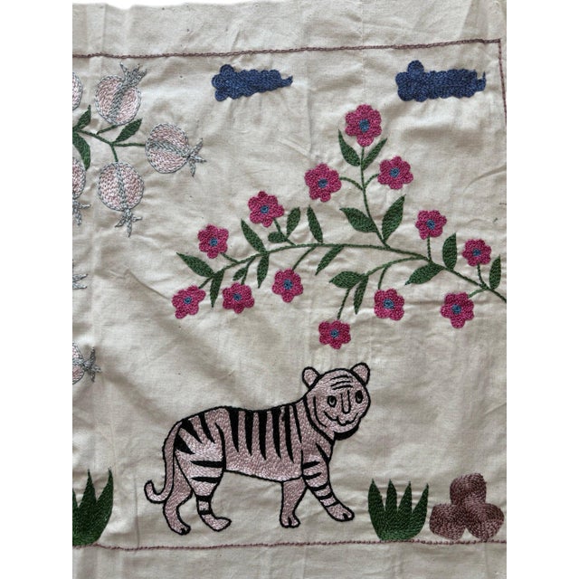 Hand-embroidered Suzani panel from Uzbekistan, worked in fine floss on a cream cotton ground. Three tigers move across the...