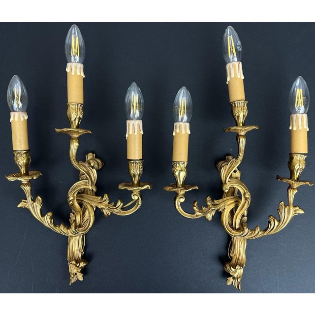 A striking pair of Vintage French sconces featuring elegant three arm styling with beautifully flowing decorative forms...