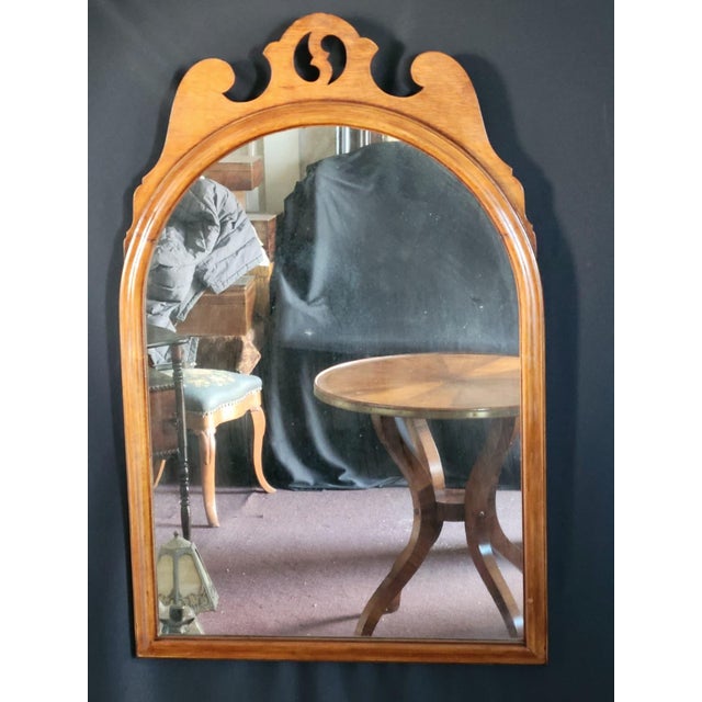 1930s Maple Hanging Wall Mirror featuring a graceful arched frame with a decorative pierced crest in the Colonial Revival...