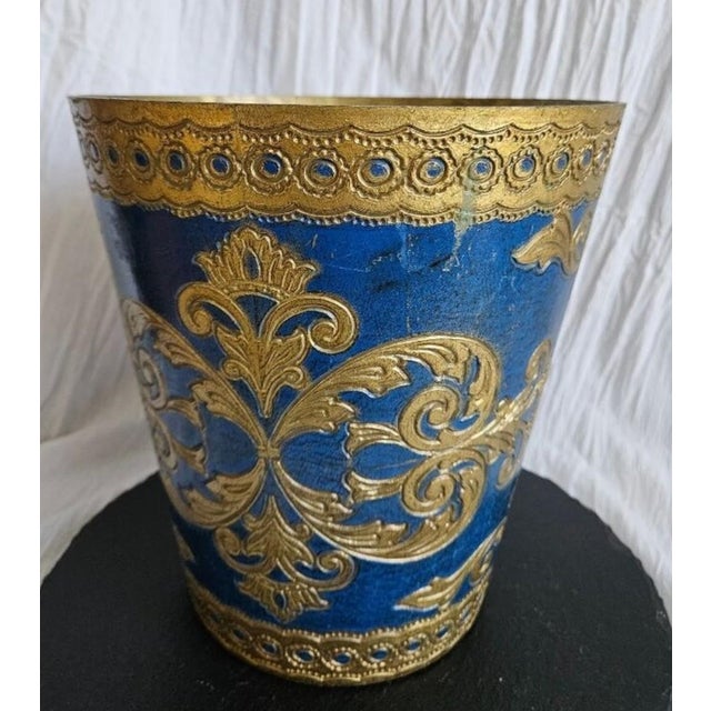 This Florentine wastebasket is a deep shade of sapphire blue with warm gilding. The combination of these colors give the...