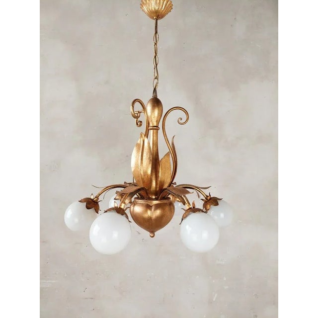 A pair of French, mMd-Century gold (gold patinated) Hollywood Regency lamps with leaves. The 6 light points of these...