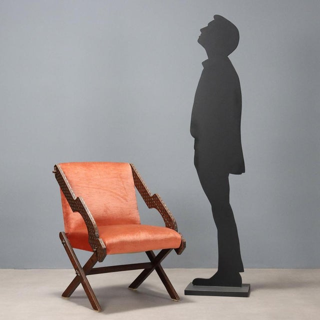 Armchair with wooden frame with exposed armrests, seat with foam padding and upholstery in original brick-colored fabric...