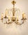 Elegant vintage crystal chandelier with 6 light points, featuring a warm brass/copper-colored frame and richly adorned...