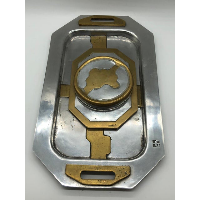 The tray set by David Marshall-Disenos is a remarkable example of the brutalist aesthetic, masterfully realized in brass...