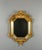 Superb antique octagonal mirror in finely carved and gilded wood, adorned with abundant rocaille decoration composed of...