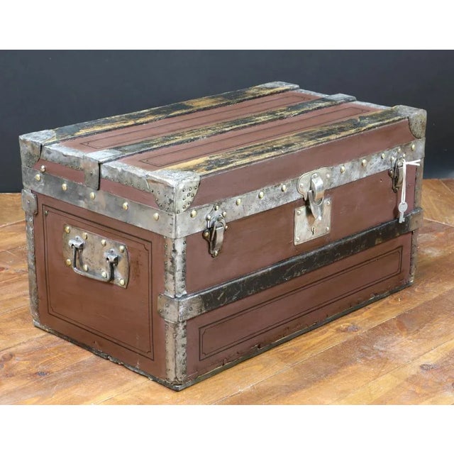 This wooden crate is lined with linen on the inside and features metal fittings.