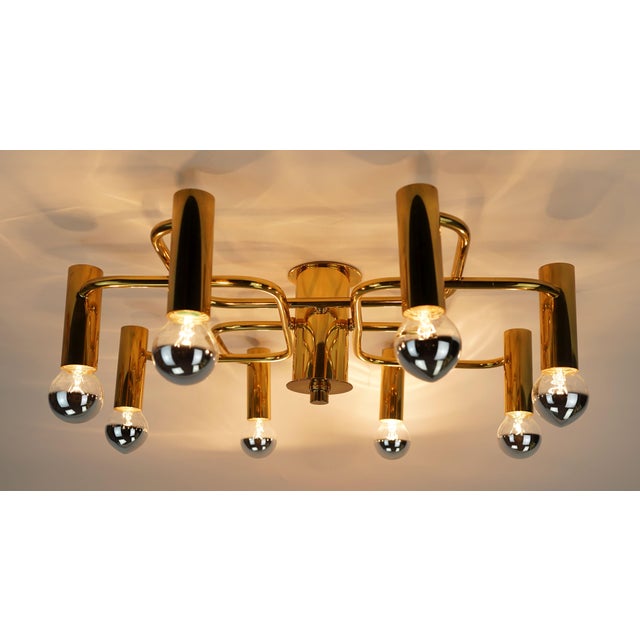 A fantastic large sputnik ceiling lamp manufactured in the 1970s. Made of brass, with 8 curved arms. For 8 E14 bulbs. The...