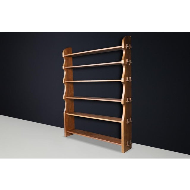 A sculptural mid-century Alpine bookcase in solid wood, featuring traditional wedge joinery and a fully demountable...