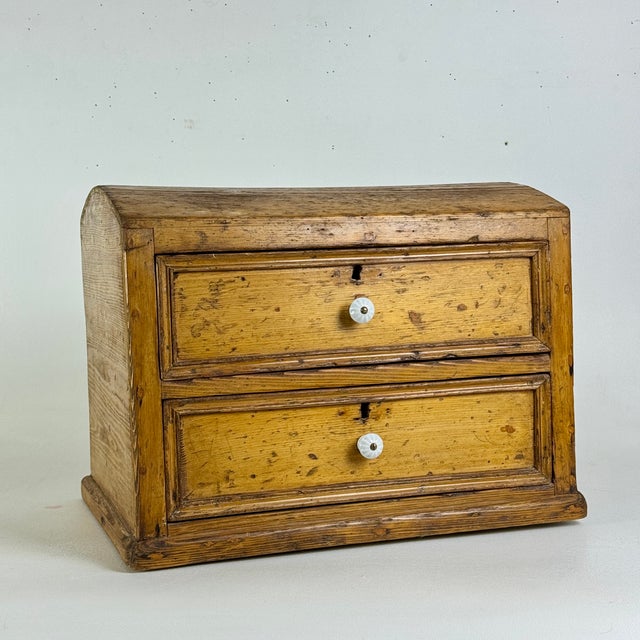 An elegant and unique two drawer antique cabinet with a treasure chest dome top. It's a character piece that's both...