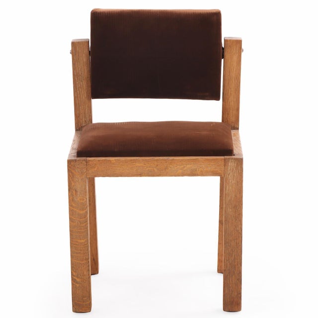 French Brutalist-style oak side chairs, circa 1960, featuring boldly constructed frames and fully tilting backs. The...
