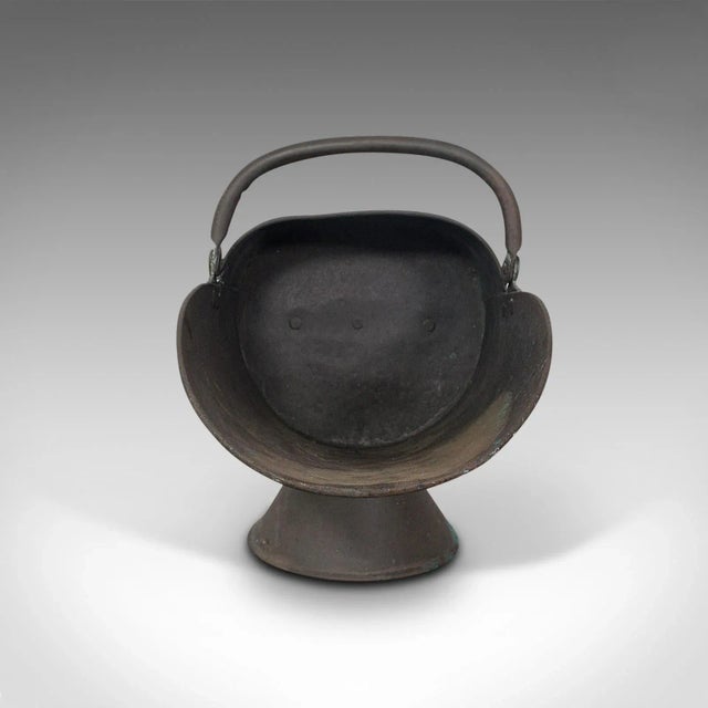 This is an antique helmet scuttle. An English, copper fireside coal or log bucket, dating to the Victorian period, circa...