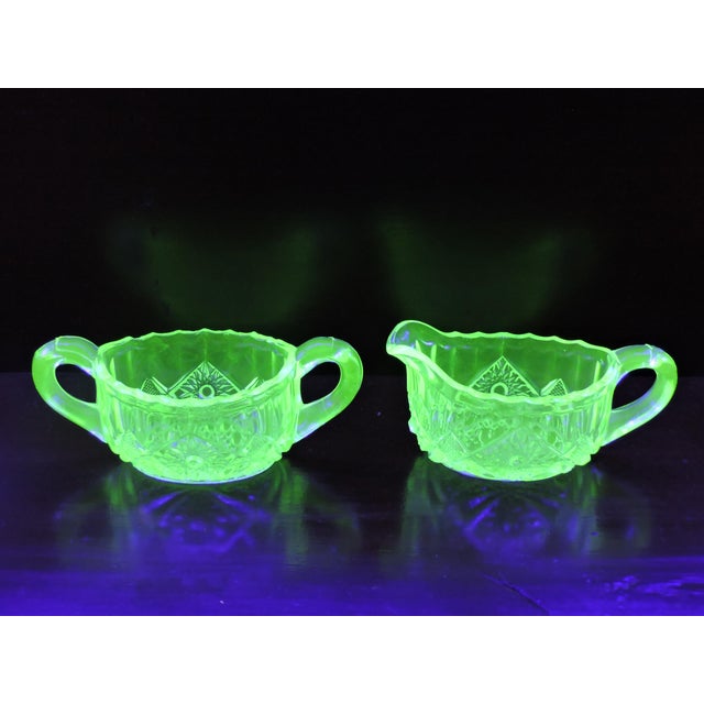 This early American pressed glass dolphin green sugar and creamer set was made by the Mckee Glass Co. from Jeannette P.A...
