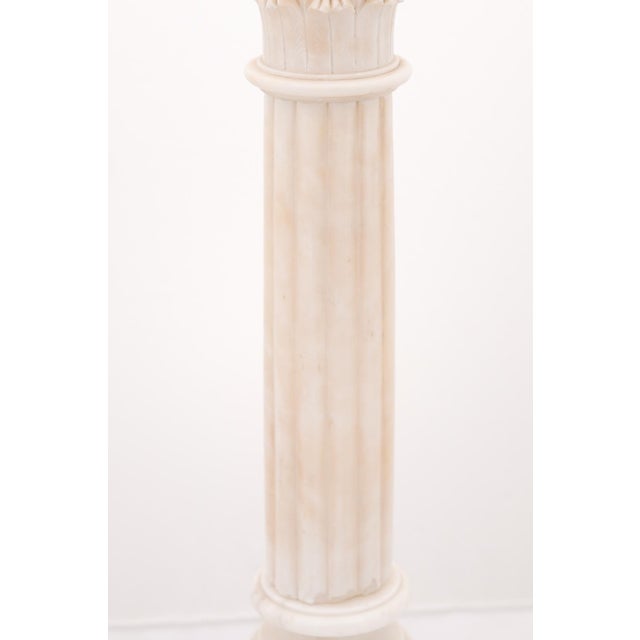 A pair of large Neo-Classical fluted alabaster column lamps with stepped bases. These pieces have a wonderful natural...