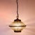 Pendant lamp with prismatic glass, perfectly diffuses the light, finished with a round patinated brass cover, reminiscent...