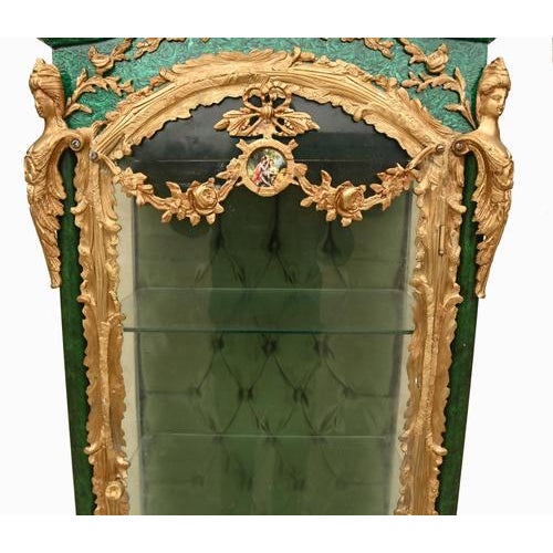 A spectacular pair of french vitrines in the louis xvi style, richly adorned with carved giltwood and striking faux...