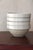 A traditional French ironstone bowl in a creamy off-white glaze, with a wide flat rim, slightly rounded body and footed...