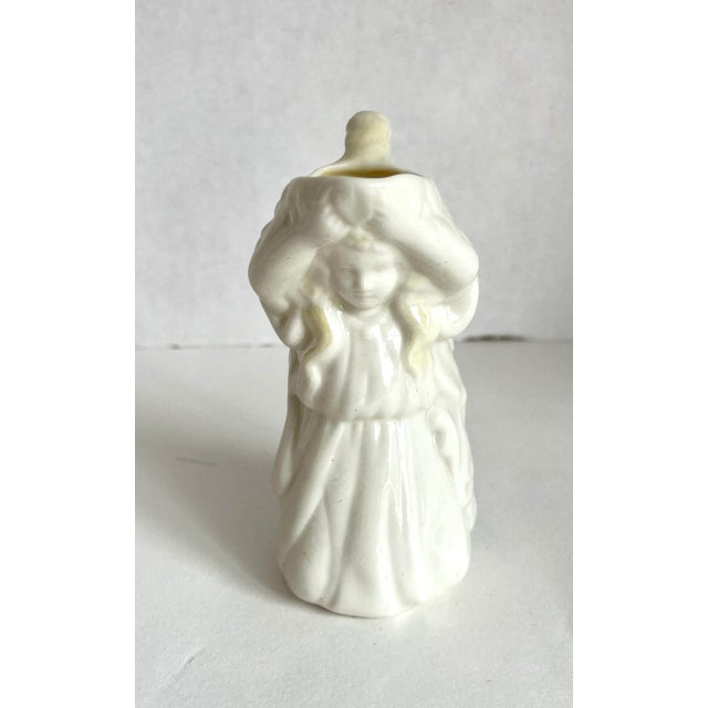 Here is a beautiful porcelain creamer made by Belleek Pottery in the 1940's. The piece features a lovely female figure in...